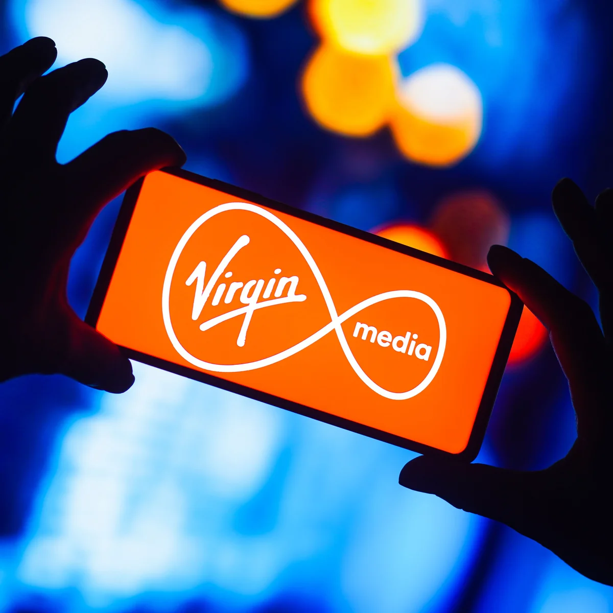 Virgin Media logo displayed on a smartphone screen, representing the telecoms operator amid investor scrutiny of its £22bn debt.