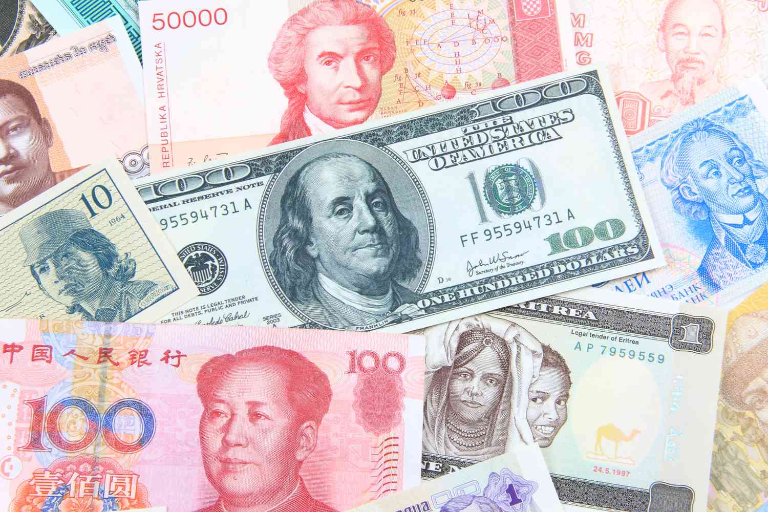 Assorted world currency banknotes and coins spread out, representing foreign exchange markets