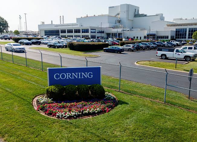 Corning corporate signage with fibre-optic connectivity imagery.